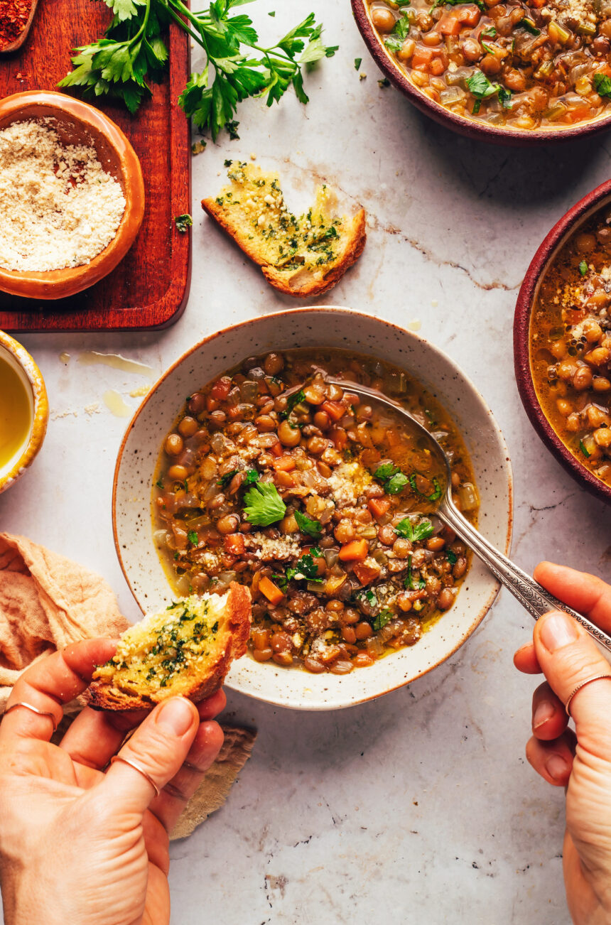 Bowls of Italian lentil soup with slices of garlic bread