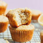 Stack of vegan gluten-free lemon poppy seed muffins with the inner texture showing where a bite was taken out of one muffin