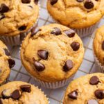 Kodiak cake muffins with chocolate chips on top, cooling on a wire rack.