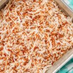 toasted coconut in pan over light blue napkin