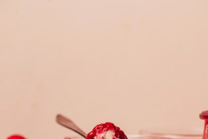Glass dessert jars of our no-bake chocolate cheesecake cups with some topped with raspberries and others raspberry compote