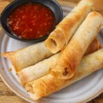 air fried lumpia on small plate with dipping sauce