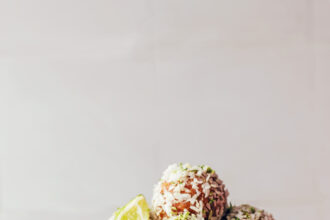 Bowl of no-bake coconut lime energy bites and lime slices