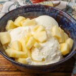 horizontal photo of ice cream with pineapple in a blue bowl