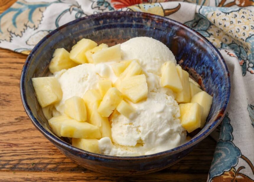 horizontal photo of ice cream with pineapple in a blue bowl
