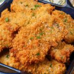 close up of fried pork cutlets in blue dish