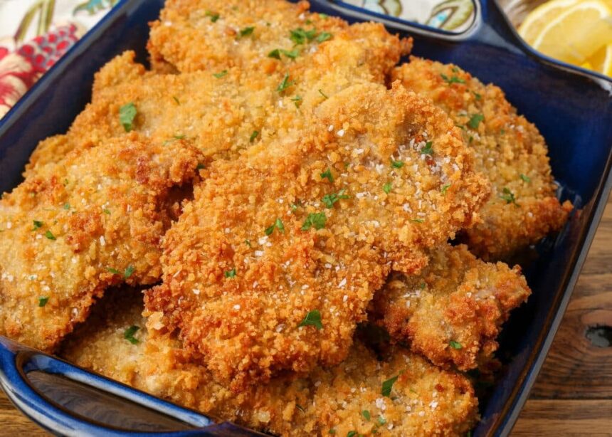 close up of fried pork cutlets in blue dish
