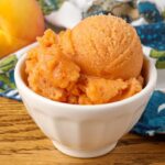 peach sorbet in white bowl on table