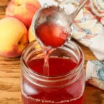 peach syrup in jar with silver ladle