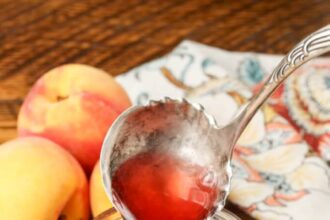 peach syrup in jar with silver ladle