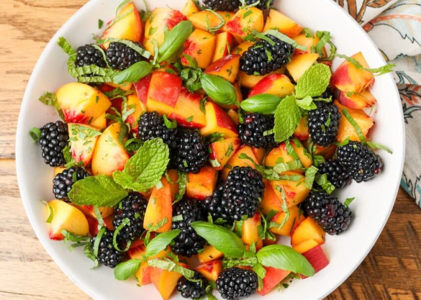 peaches and blackberries and herbs on white plate