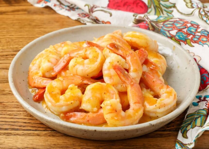 shrimp with an orange garlic sauce on pottery plate