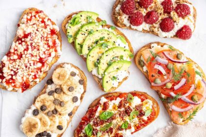 Assorted cottage cheese toast ideas topped with avocado, smoked salmon, pizza marinara, raspberries, banana with chocolate chips, and berry jam.