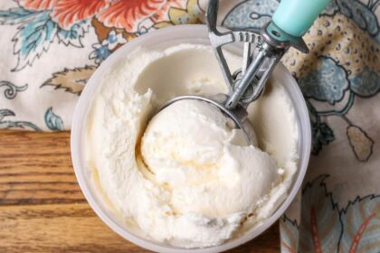 A top down image of a freezer safe container of ice cream on a wooden tabletop.