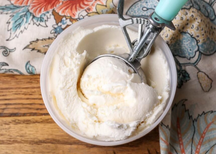 A top down image of a freezer safe container of ice cream on a wooden tabletop.