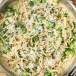 A close up horizontally aligned photo of a skillet full of chicken broccoli pasta.