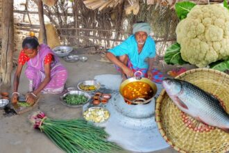Cauliflower and Rohu Fish curry and onion leaves fry cooking by santali tribe ol couple for lunch