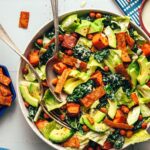 Serving spoon and fork resting in a bowl of our vegan sweet potato chickpea taco salad